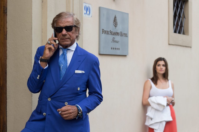 Lino Ieluzzi de la boutique de vêtements pour homme Al Bazar au téléphone à l'entrée d'un palace à Florence.